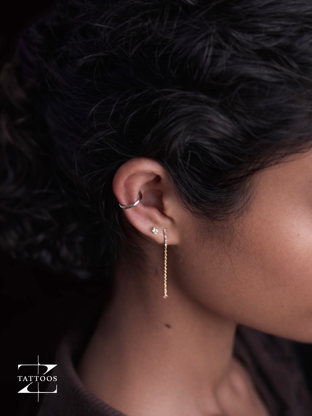 Double nostril piercing with thin hoops.